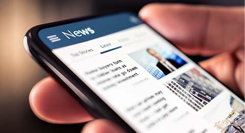 Image of person reading news on smart phone